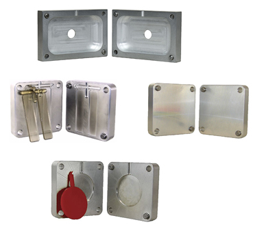 Various aluminum molds and master mold frames for benchtop plastic injection molding.